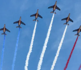 Line of fighter jets letting off red, white, and blue chemtrails