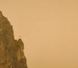 Cross on the edge of a cliff in the distance