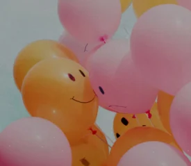 Bunch of orange and pick balloons with smiley faces