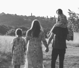 black and white photo of a family walking in a field