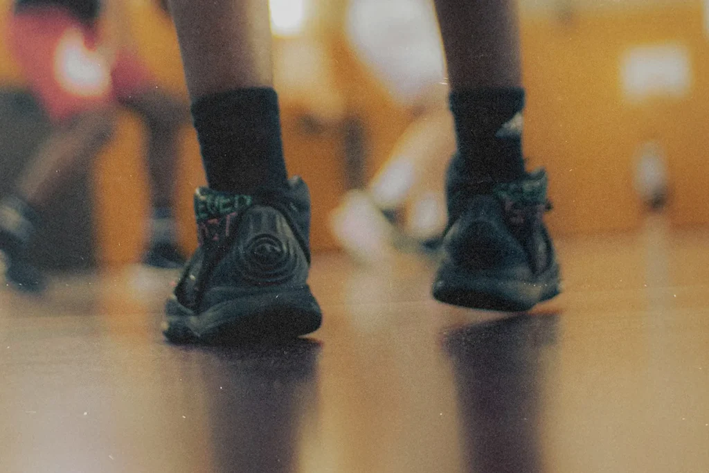 Basketball shoes taking small steps on a gym floor, symbolizing spiritual growth through everyday faith, trust in God, and consistent Kingdom living choices.