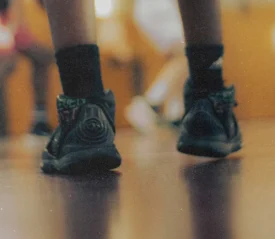 Basketball shoes taking small steps on a gym floor, symbolizing spiritual growth through everyday faith, trust in God, and consistent Kingdom living choices.
