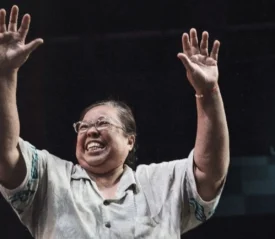 Woman holding hands up in praise.