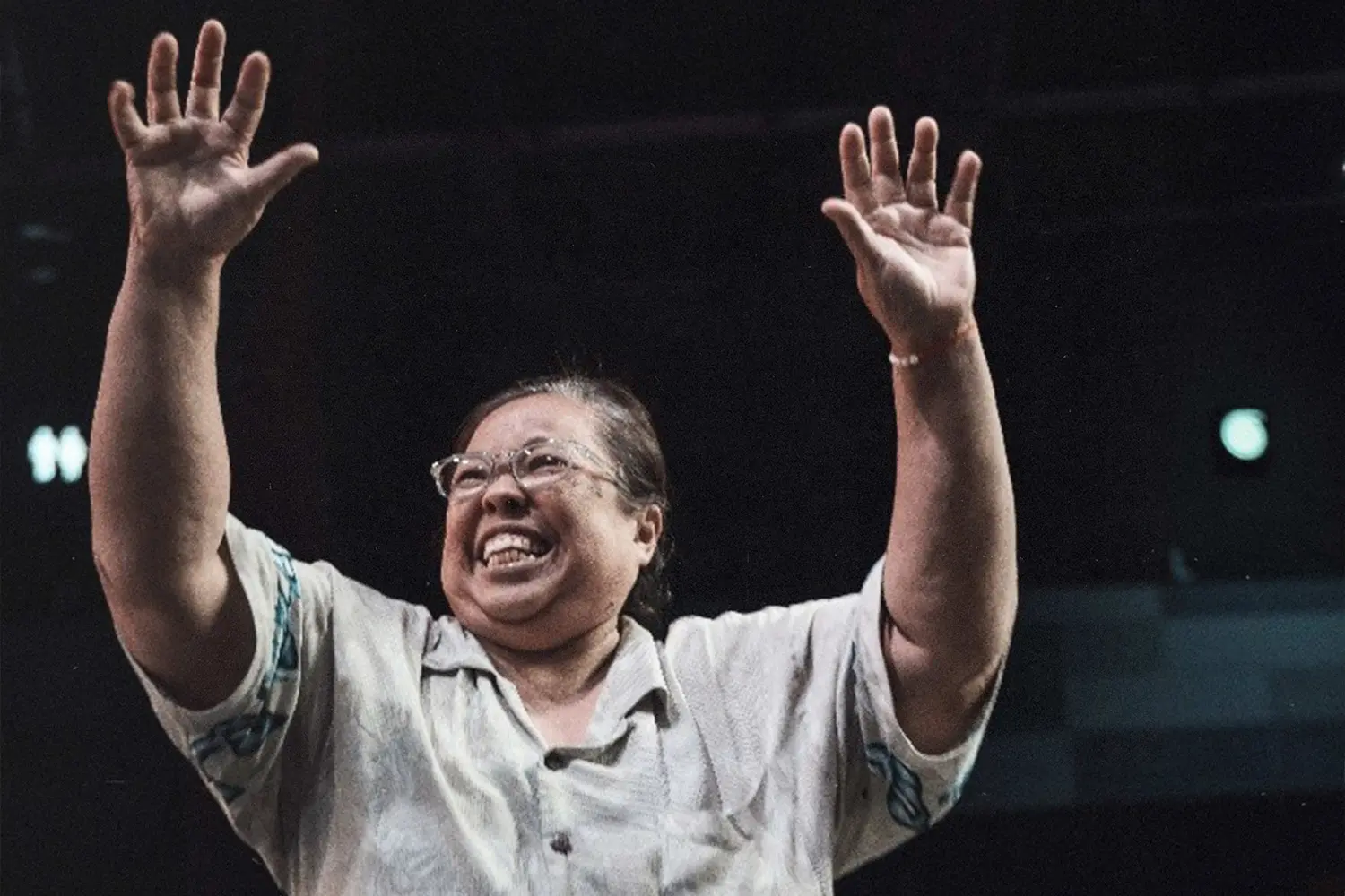 Woman holding hands up in praise.