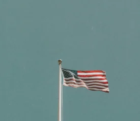 American flag in front of the blue sky.