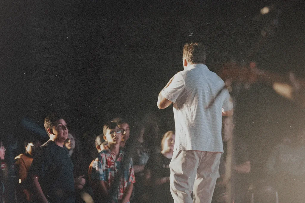 Man standing on stage facing a crowd.