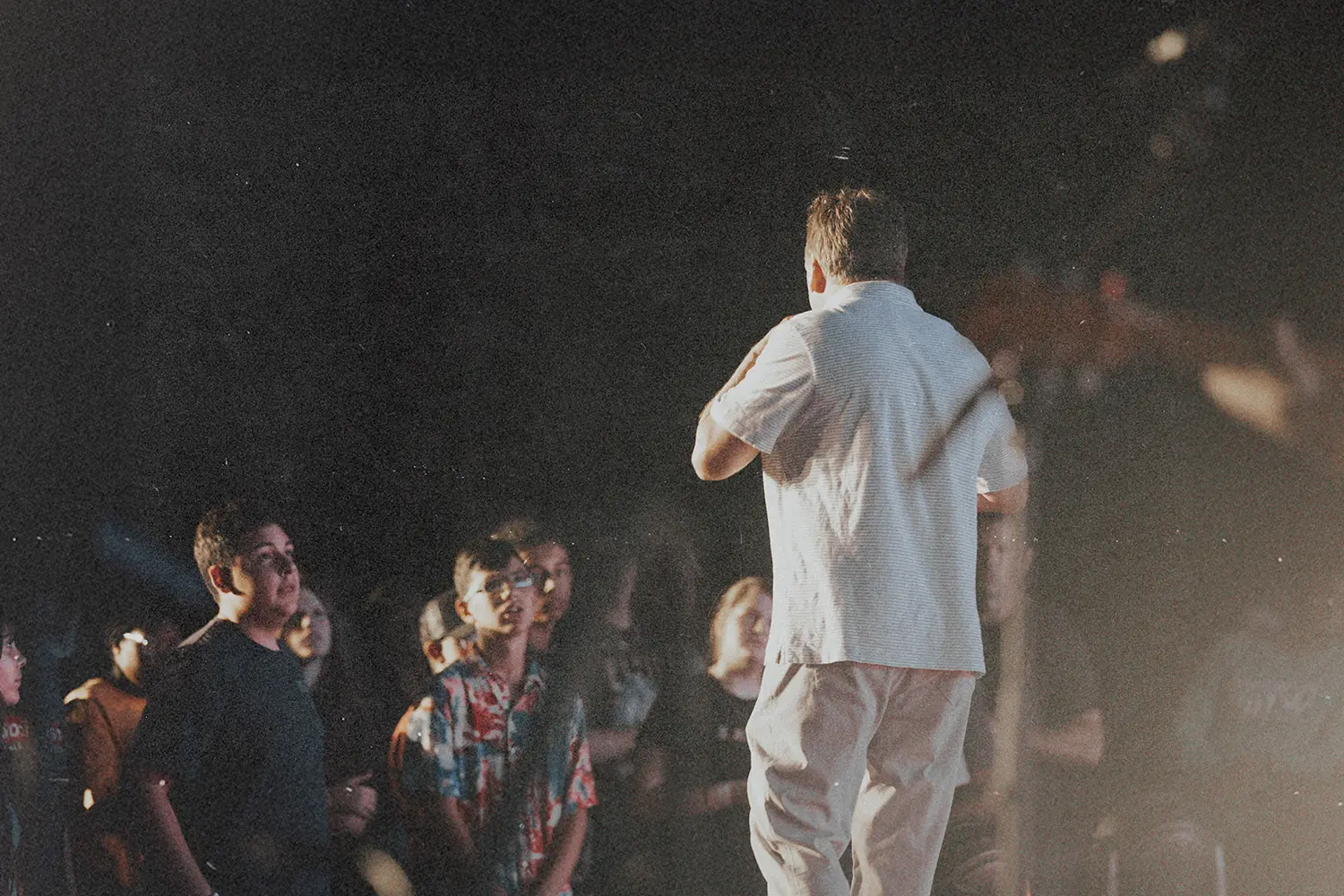 Man standing on stage facing a crowd.