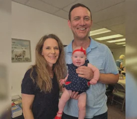 A couple holding their baby.