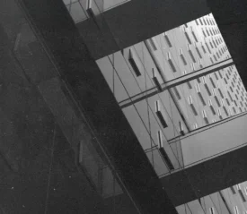 Geometric architectural reflection showing repeating window patterns on mirrored building panels