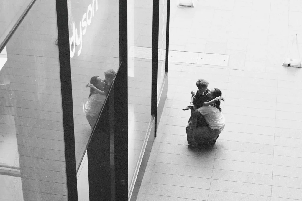 Two people embracing in a mall corridor, seen from above