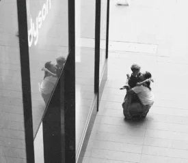 Two people embracing in a mall corridor, seen from above