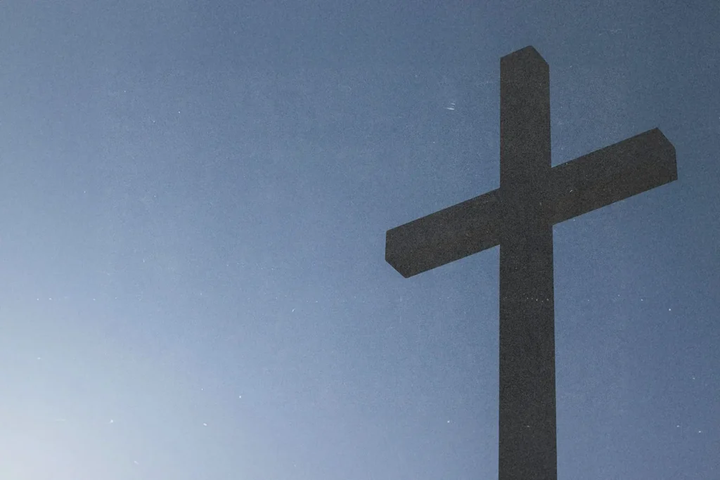 A large cross stands against a clear blue sky