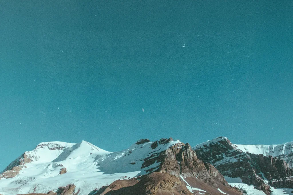 Snow‑covered mountain peaks under a clear blue sky. If you want a more keyword‑rich version (faith, stren