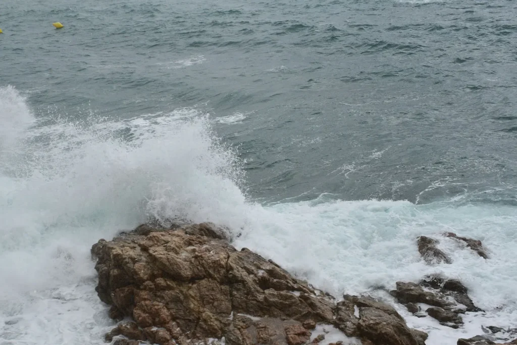 Waves crashing against rocks in the ocean, symbolizing staying strong in faith