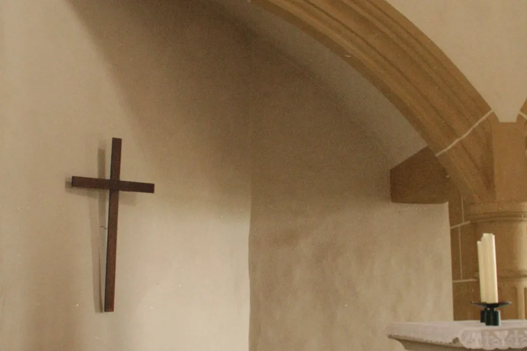 A cross on a wall of a small stone church