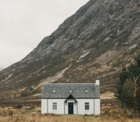 A remote house on a cloudy day, representing a safe place hidden from the storms of life.