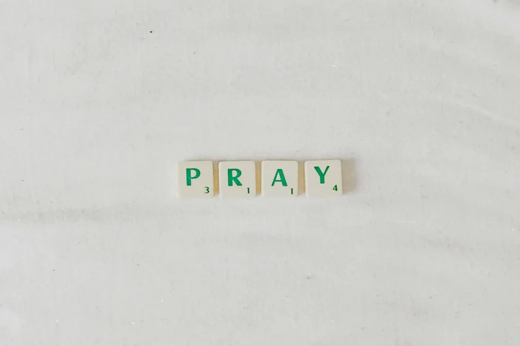 Green Scrabble pieces that spell "PRAY"