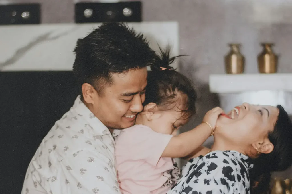 Happy parents in the kitchen playing with their toddler daughter