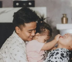 Happy parents in the kitchen playing with their toddler daughter