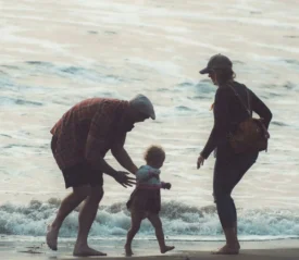 Grandparents playing with grandchild at the beach