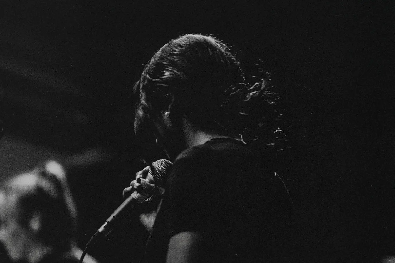 Woman holding a microphone worshipping