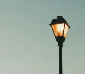 Street lamp lit with a clear sky in the background