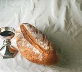 Table with a chalice of wine and loaf of bread