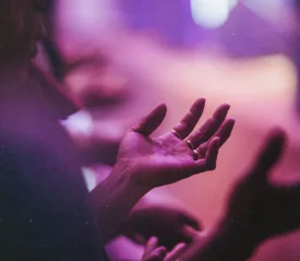 Closeup of person with open palms lifted in praise
