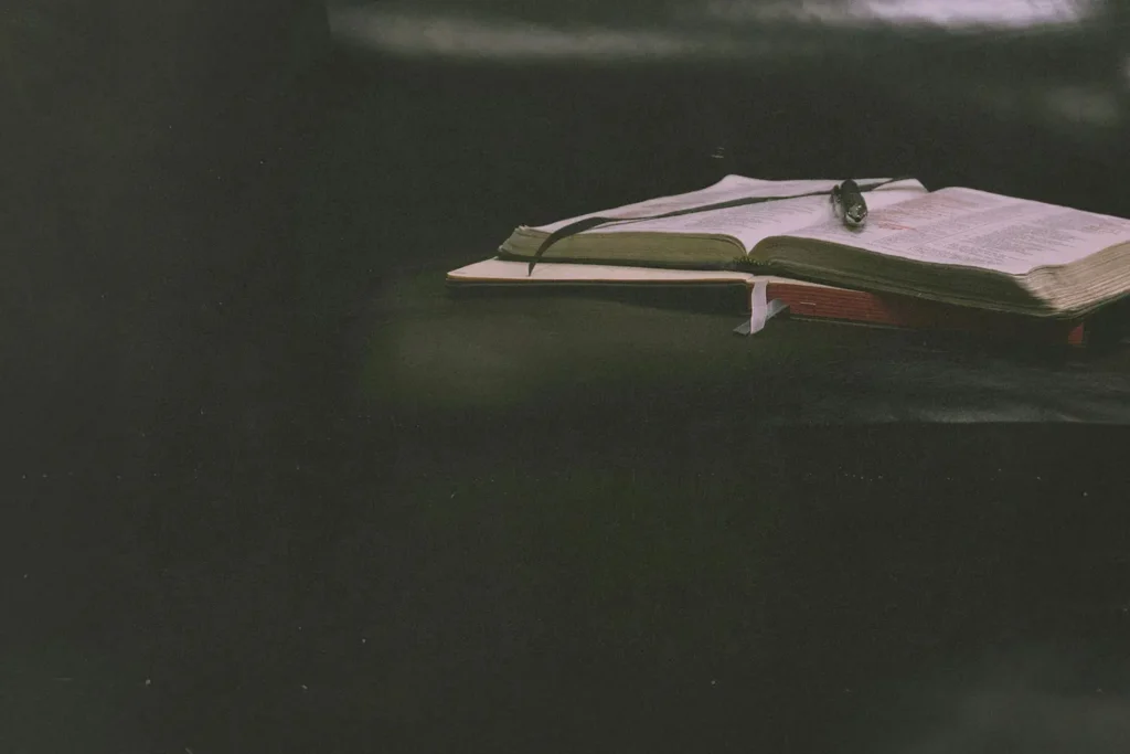 An open Bible and notebook on a table
