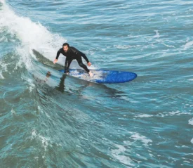Man riding a wave on a blue surfboard