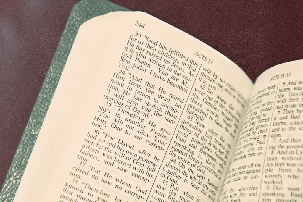 An open Bible lies on a surface with the text clearly visible on the page labeled Acts 13