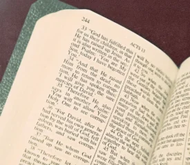 An open Bible lies on a surface with the text clearly visible on the page labeled Acts 13