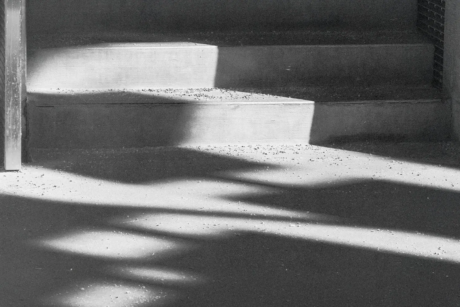 Sunlight casts geometric shadows across a set of concrete steps