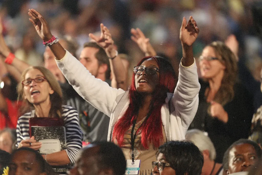 Woman with eyes closed and hands raised in worship