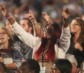 Woman with eyes closed and hands raised in worship
