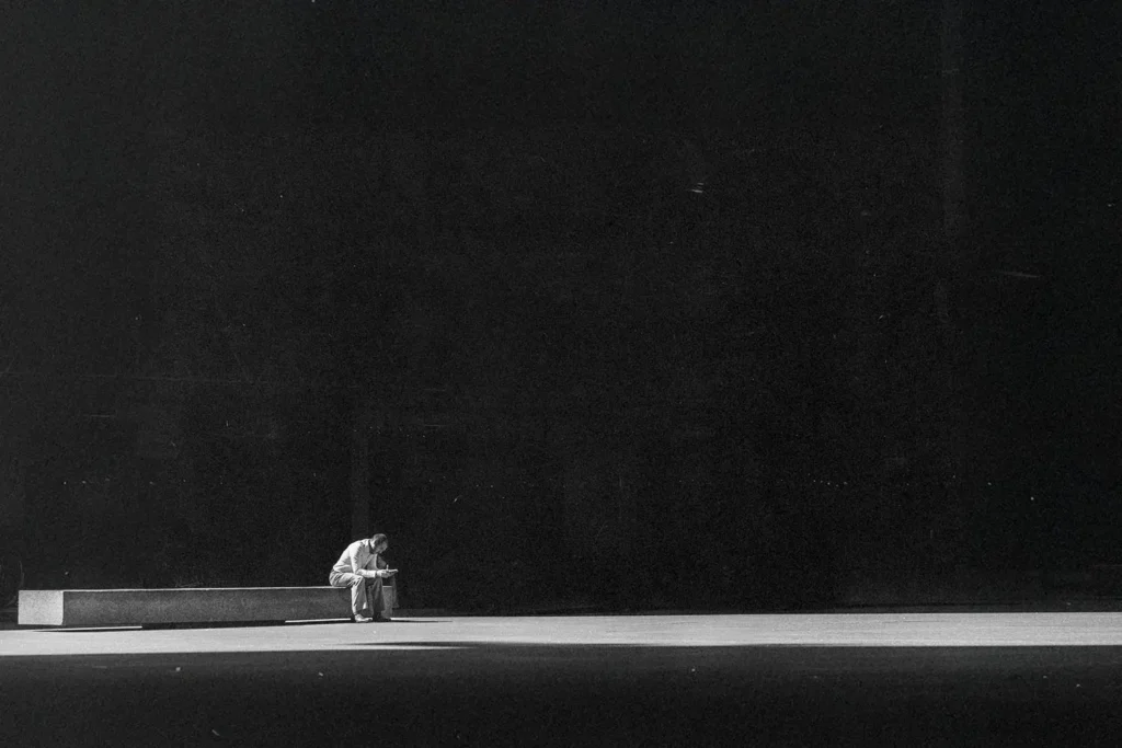 Spotlight shining on a man sitting on a big stage