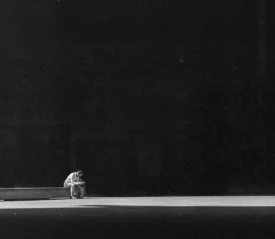 Spotlight shining on a man sitting on a big stage