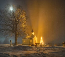 Snow‑covered church glowing with warm golden lights at night, with a lit Christmas tree and a large bare tree under a bright moon