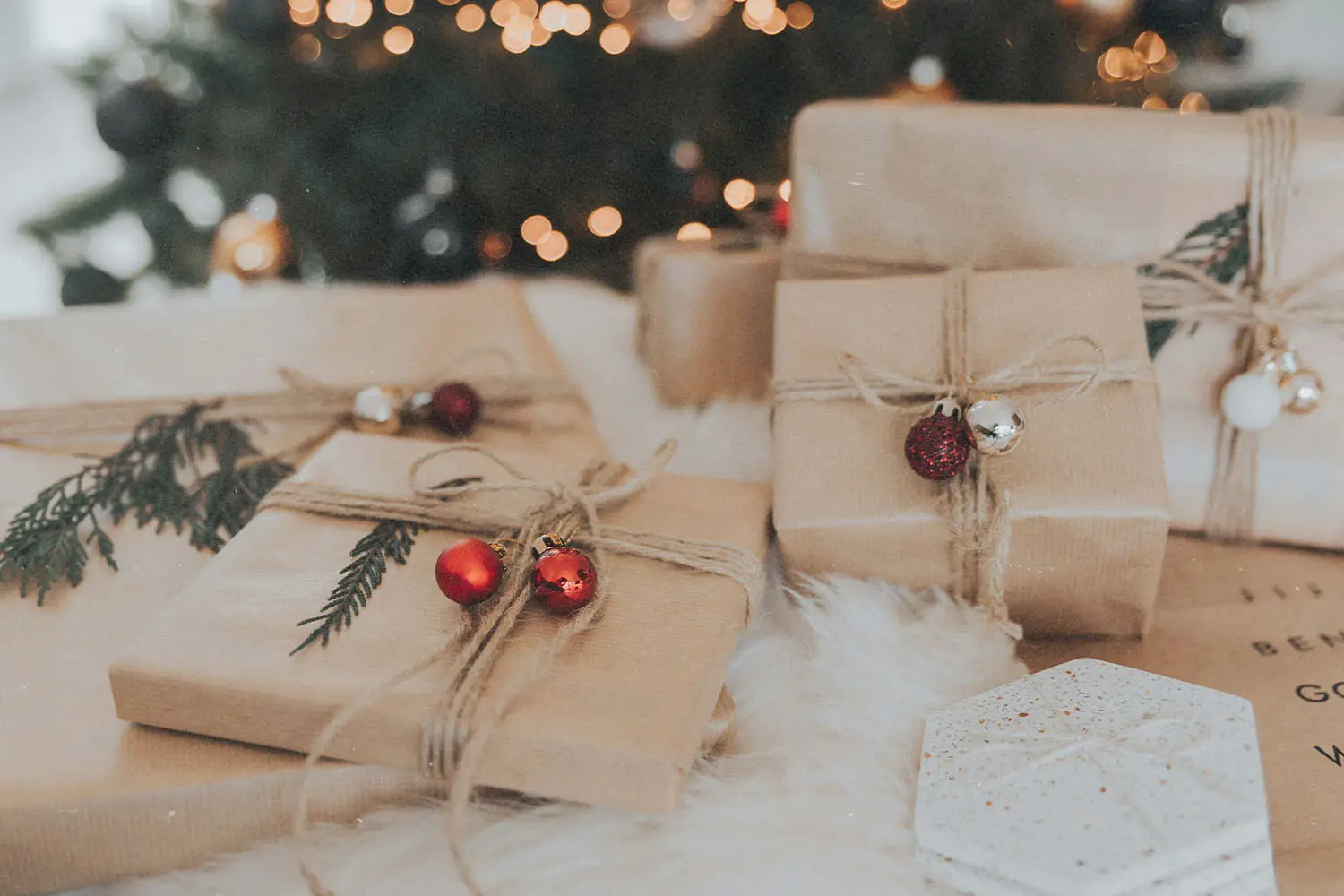 brown paper wrapped gifts under a christmas tree