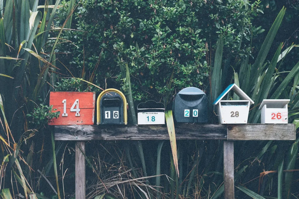 Line of mailboxes of different shapes, colors, and numbers