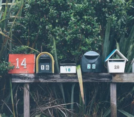 Line of mailboxes of different shapes, colors, and numbers