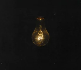 Dark background with a dimly lit light bulb hanging
