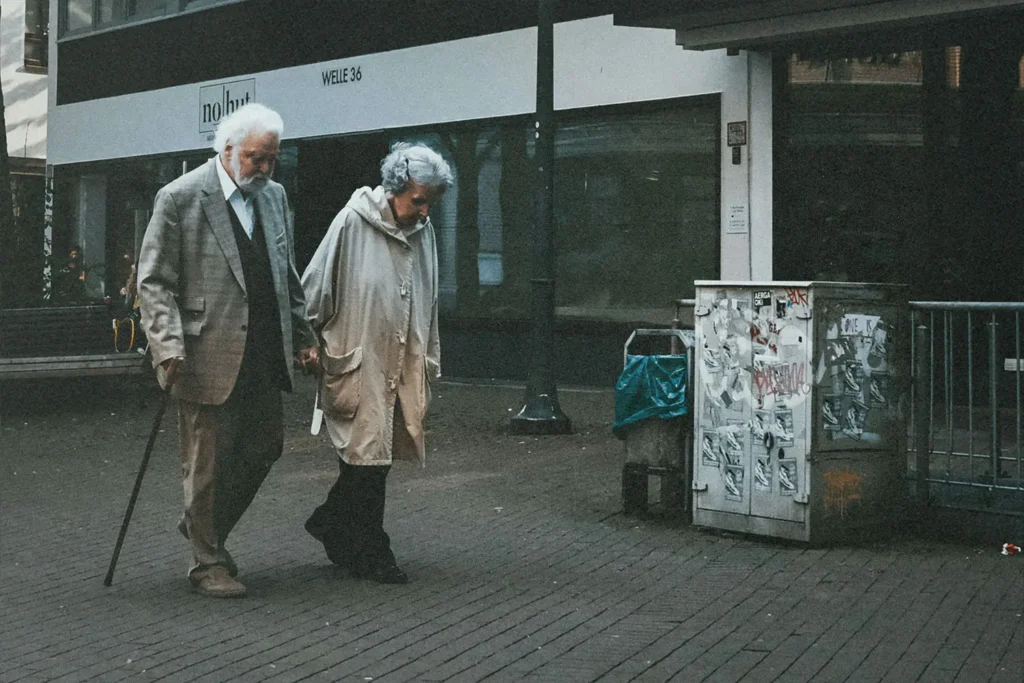Elderly couple holding hands walking down the street