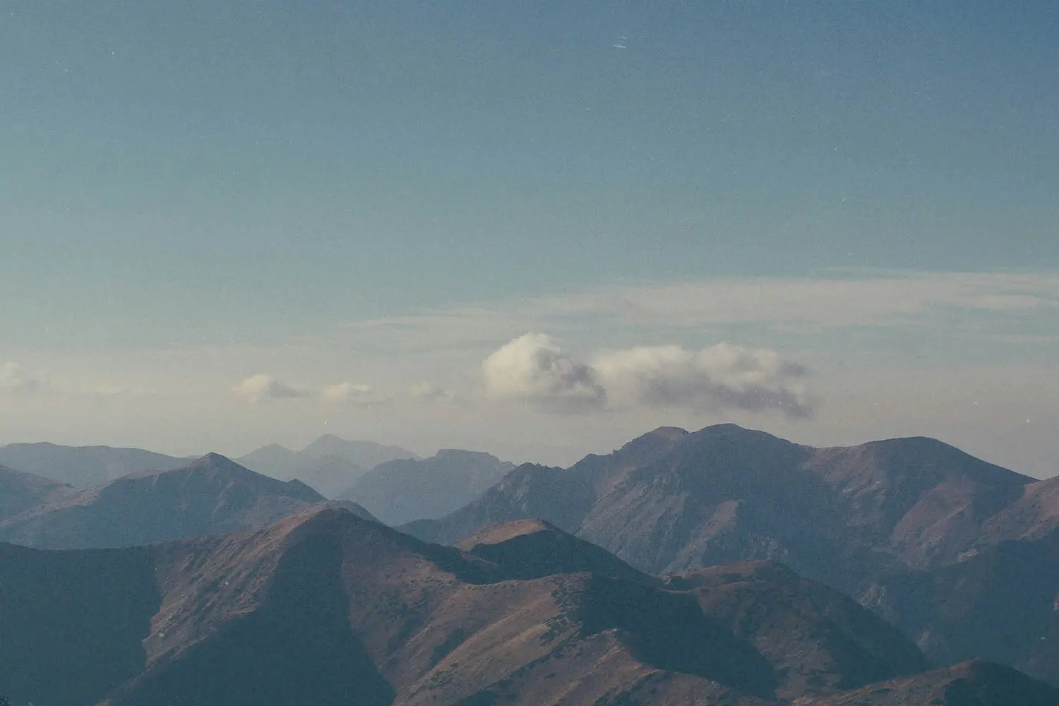 mountain range with a cloud above