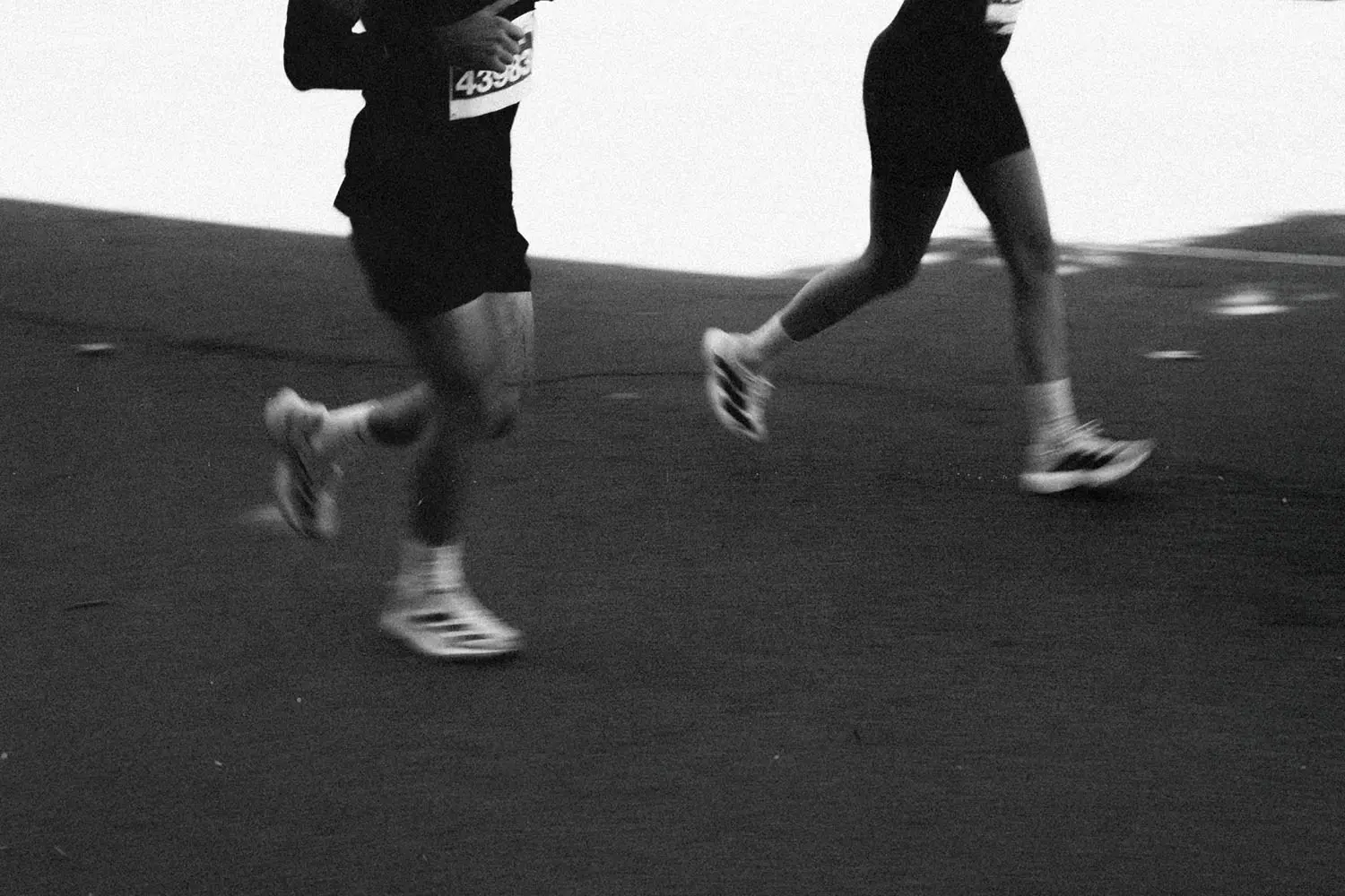 black and white photo of two people running in a marathon