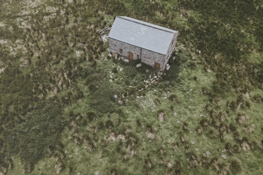 birdseye view of a building in the middle of a lush field