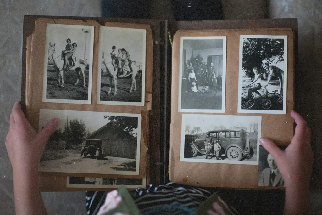 person looking through a vintage photo book of black and white photos
