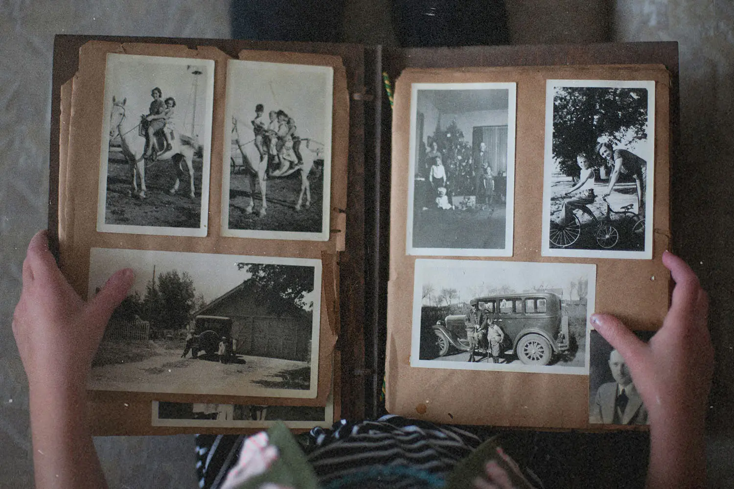 person looking through a vintage photo book of black and white photos