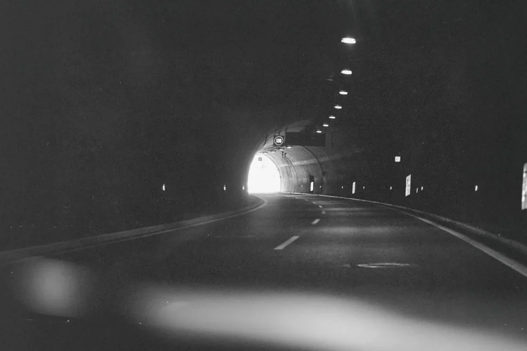Car driving through a dimly lit tunnel
