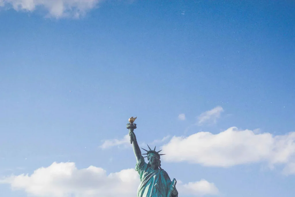 top of statue of liberty with clouds in the sky